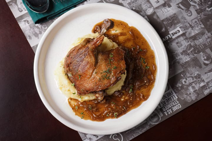 Duck Confit with mashed potato and onion gravy at Le Café des Stagiaires
